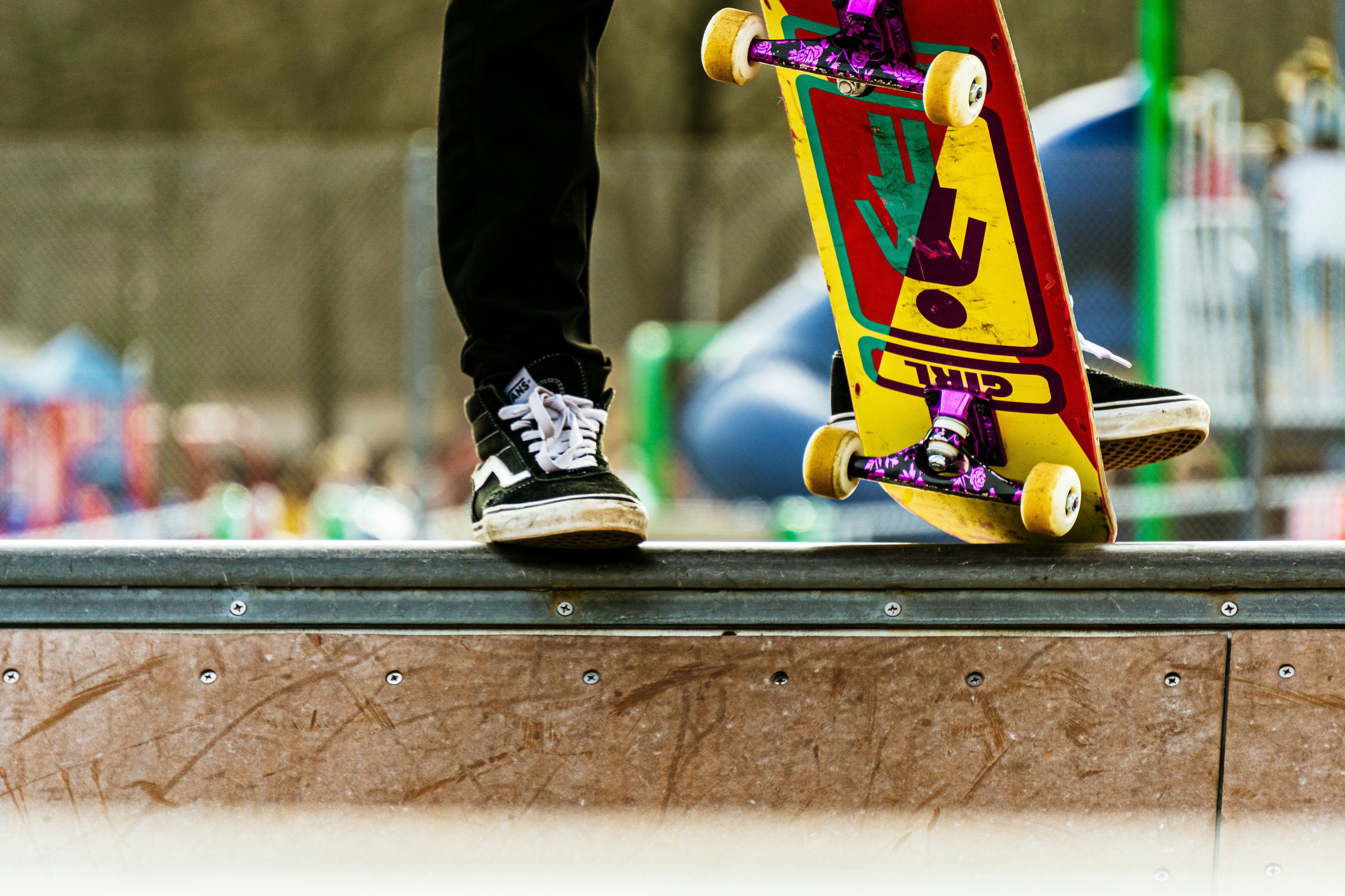person stepping on a skateboard with multicolored print