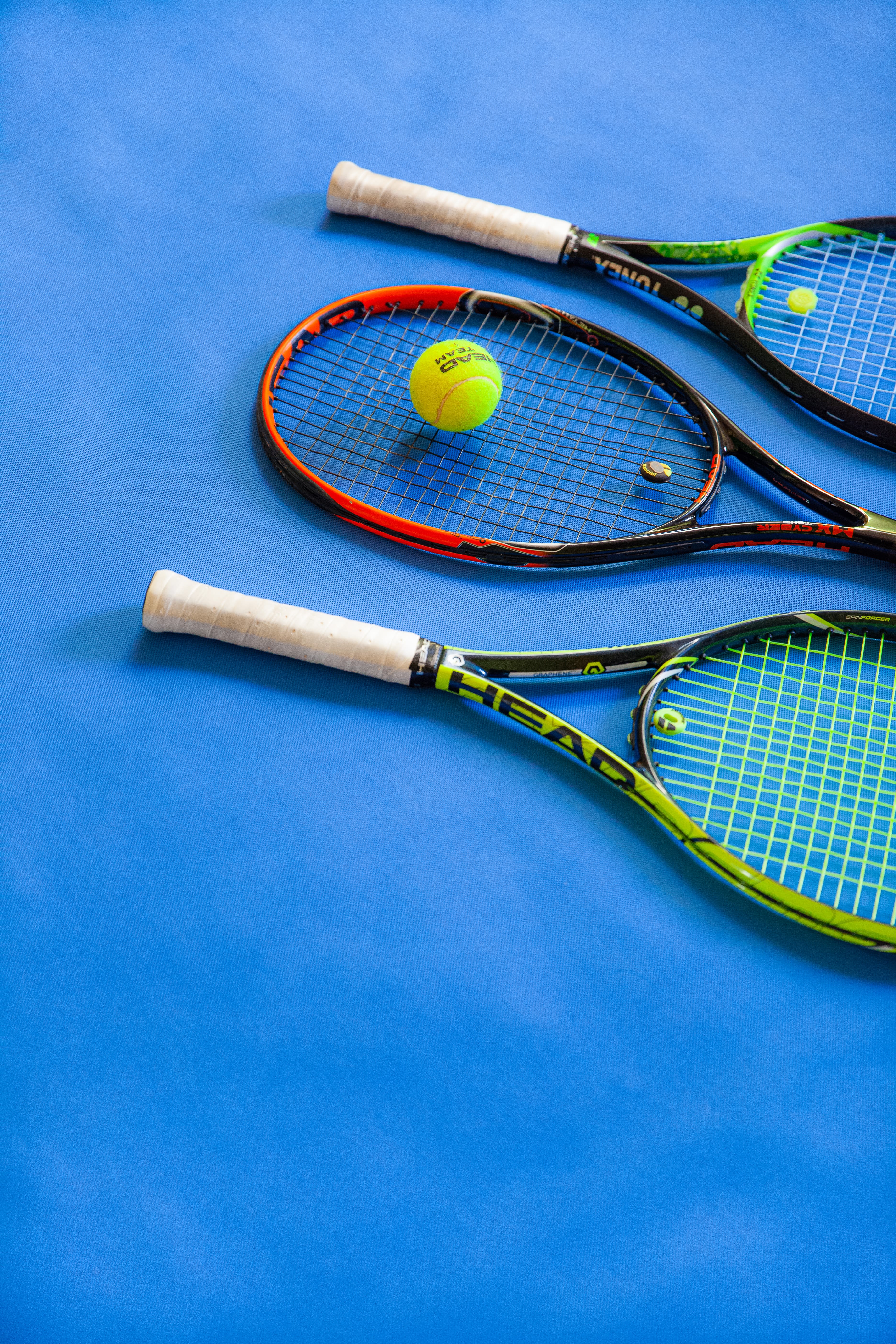 yellow and black tennis racket on blue textile